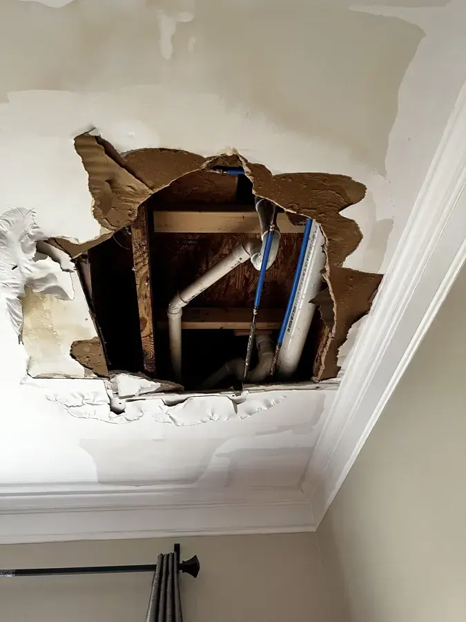 Ceiling opened below a leaking bathroom drain line in a Lodi home